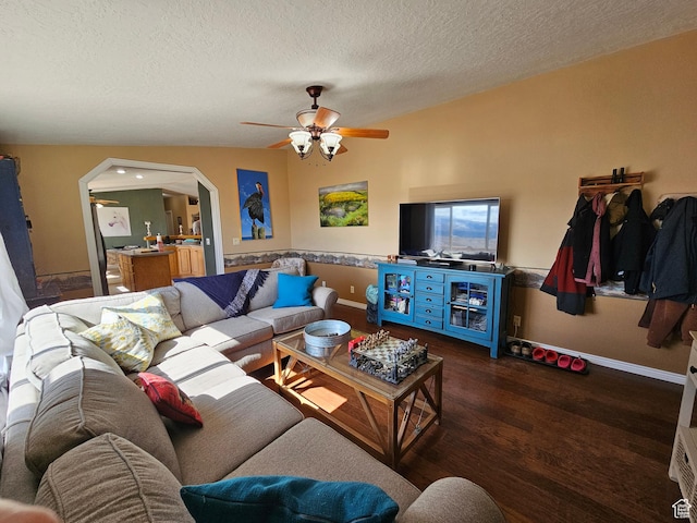 living room featuring wood finished floors, a textured ceiling, baseboards, arched walkways, and ceiling fan