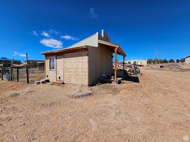 view of outbuilding featuring fence and an outdoor structure