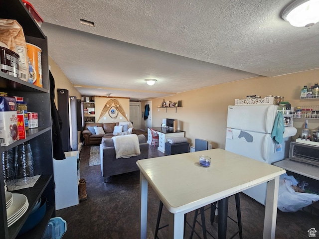 kitchen featuring a textured ceiling and freestanding refrigerator