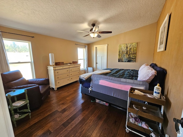 bedroom with a textured ceiling, wood finished floors, vaulted ceiling, and a ceiling fan