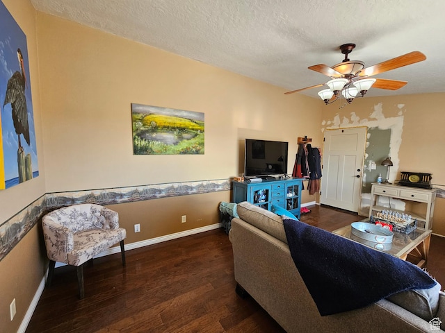 living room featuring a textured ceiling, baseboards, ceiling fan, and wood finished floors
