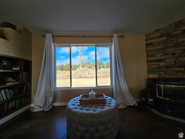 sitting room featuring baseboards, a textured ceiling, and dark wood-style floors
