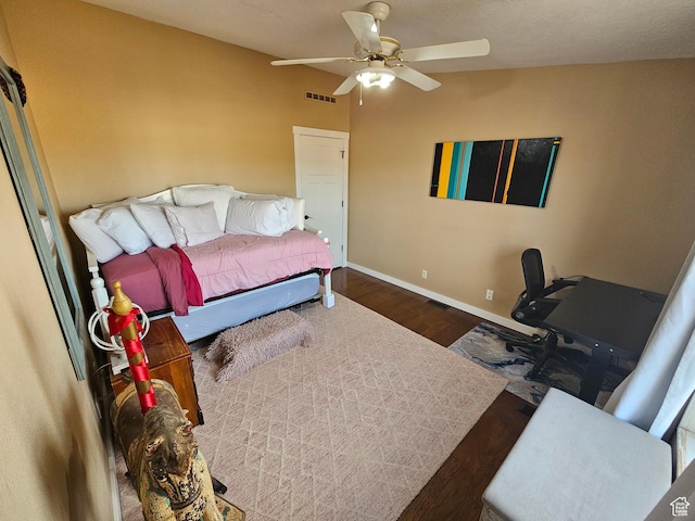 bedroom with visible vents, baseboards, ceiling fan, and wood finished floors