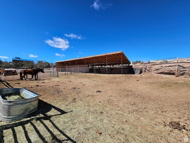 view of yard featuring an outbuilding, an exterior structure, and a rural view