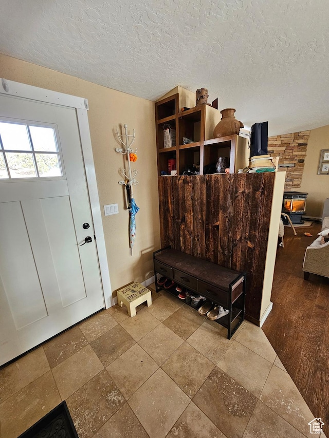 foyer featuring baseboards and a textured ceiling