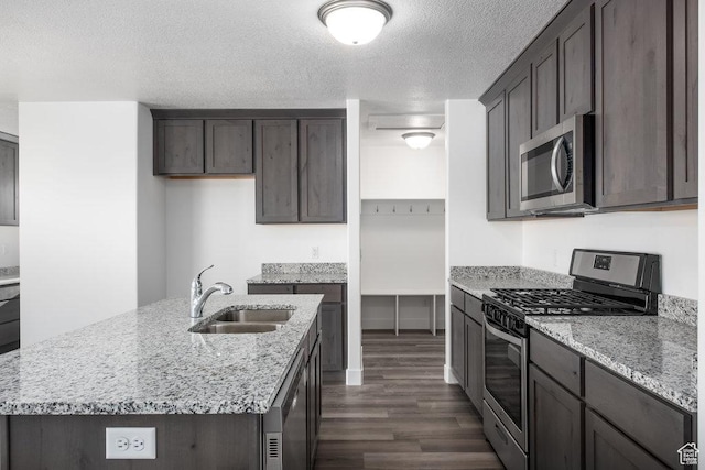 1167 W Rocky Way Unit 617, Grantsville, UT 84029 - kitchen with dark wood-style flooring, a sink, light stone counters, dark brown cabinets, and appliances with stainless steel finishes