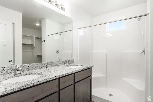 1167 W Rocky Way Unit 617, Grantsville, UT 84029 - bathroom with a shower stall, double vanity, a walk in closet, and a sink
