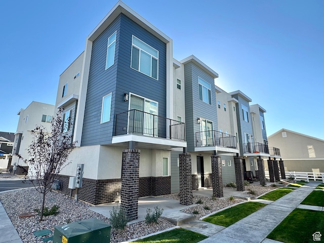 exterior space with a residential view, brick siding, and stucco siding