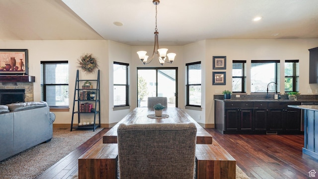 198 E Cameron Dr, Saratoga Springs, UT 84045 - dining room with a stone fireplace, dark wood-type flooring, baseboards, and a chandelier