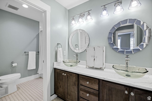 116 N 820 E, Hyde Park, UT 84318 - bathroom with double vanity, visible vents, toilet, and a sink