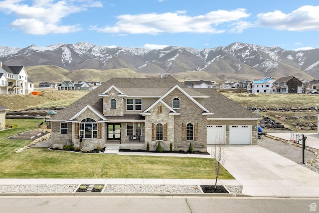 view of front of house featuring stone siding, a shingled roof, concrete driveway, and a front yard