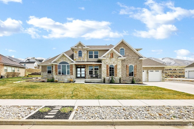 116 N 820 E, Hyde Park, UT 84318 - view of front of house featuring a front yard, stone siding, concrete driveway, an attached garage, and a mountain view