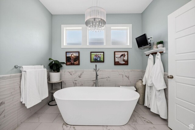 116 N 820 E, Hyde Park, UT 84318 - bathroom featuring a freestanding tub, a wainscoted wall, marble finish floor, tile walls, and an inviting chandelier