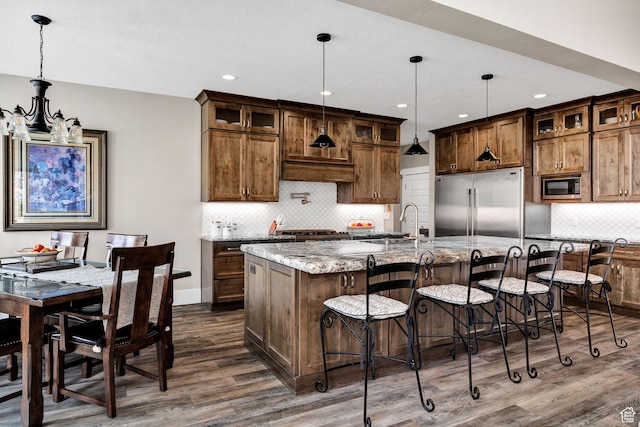 116 N 820 E, Hyde Park, UT 84318 - kitchen with dark wood-style flooring, stainless steel appliances, an island with sink, light stone countertops, and glass insert cabinets