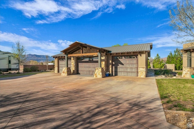 580 S 920 W, Hurricane, UT 84737 - view of front of property with stone siding, concrete driveway, an attached garage, metal roof, and a mountain view