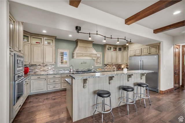 580 S 920 W, Hurricane, UT 84737 - kitchen featuring custom range hood, dark wood finished floors, an island with sink, built in appliances, and beamed ceiling