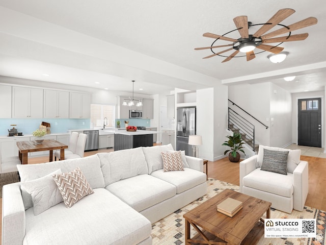 14353 S Ashvale Dr, Herriman, UT 84096 - living area with stairs, light wood-style flooring, ceiling fan, baseboards, and recessed lighting