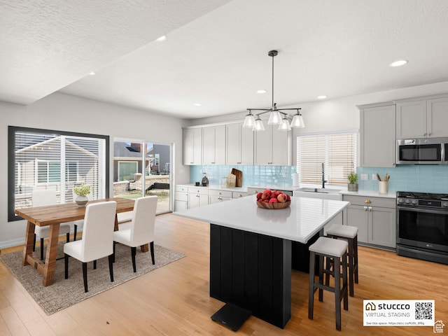 14353 S Ashvale Dr, Herriman, UT 84096 - kitchen featuring stainless steel appliances, a sink, gray cabinetry, light countertops, and recessed lighting