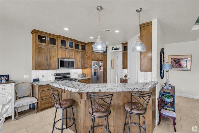 875 E Roadrunner Dr, Washington, UT 84780 - kitchen featuring decorative backsplash, stainless steel appliances, brown cabinets, and visible vents