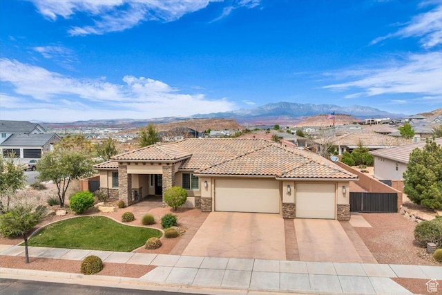 875 E Roadrunner Dr, Washington, UT 84780 - mediterranean / spanish-style house featuring stone siding, a tile roof, a mountain view, and an attached garage