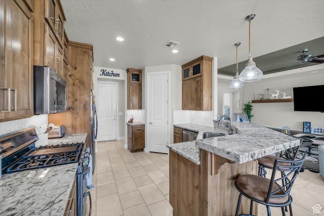 875 E Roadrunner Dr, Washington, UT 84780 - kitchen featuring visible vents, a peninsula, a breakfast bar, appliances with stainless steel finishes, and a sink