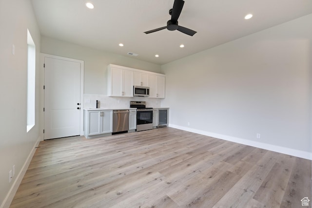 1516 W 800th Cir S, Hurricane, UT 84737 - kitchen with light wood finished floors, baseboards, ceiling fan, stainless steel appliances, and white cabinetry