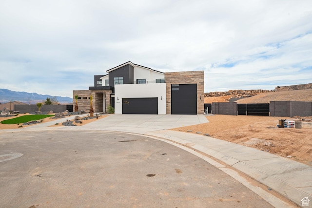 1516 W 800th Cir S, Hurricane, UT 84737 - contemporary home with stone siding, concrete driveway, stucco siding, an attached garage, and a mountain view