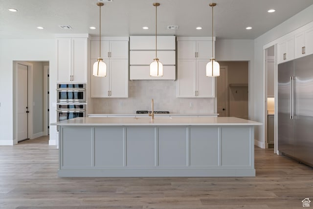 1516 W 800th Cir S, Hurricane, UT 84737 - kitchen featuring light countertops, an island with sink, backsplash, and appliances with stainless steel finishes