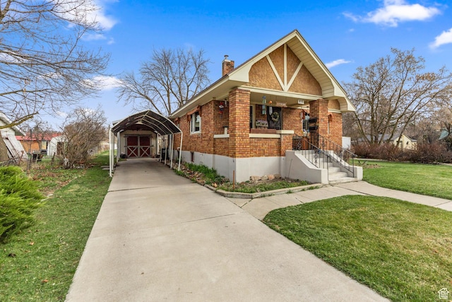 325 E 300 S, Logan, UT 84321 - view of front of house featuring brick siding, a chimney, a carport, a front yard, and driveway