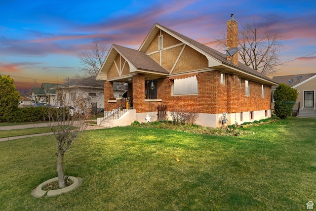 325 E 300 S, Logan, UT 84321 - tudor-style house with brick siding, a lawn, a chimney, and a shingled roof