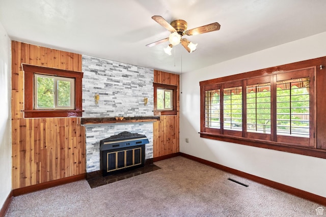 325 E 300 S, Logan, UT 84321 - unfurnished living room featuring baseboards, a ceiling fan, wooden walls, carpet, and a stone fireplace