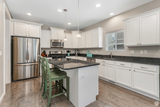 15226 S Glory Dr W, Bluffdale, UT 84065 - kitchen with a sink, a kitchen island, white cabinetry, wood finished floors, and stainless steel appliances