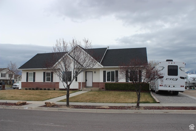 single story home featuring brick siding and a front lawn