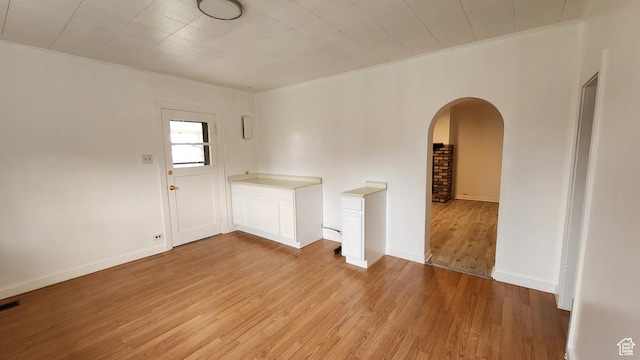 84 N 550 E, Spring City, UT 84662 - empty room featuring crown molding, light wood-style flooring, baseboards, visible vents, and arched walkways