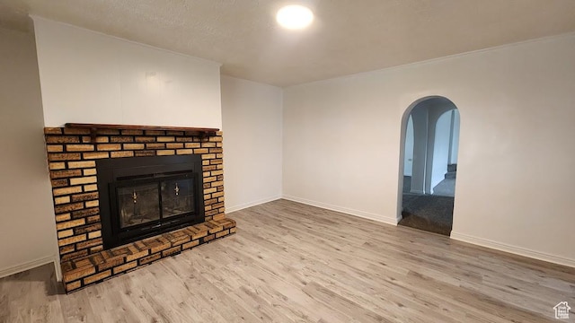 84 N 550 E, Spring City, UT 84662 - unfurnished living room with a textured ceiling, baseboards, a fireplace, wood finished floors, and arched walkways