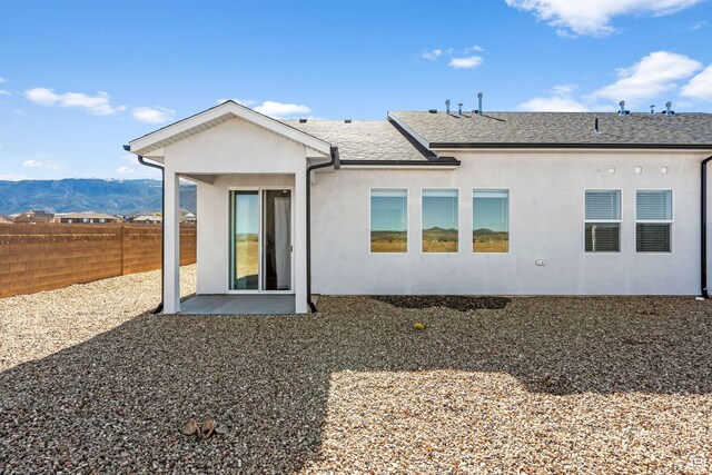 2841 N Rosie Loop N, Cedar City, UT 84721 - rear view of property featuring roof with shingles, a mountain view, stucco siding, and fence