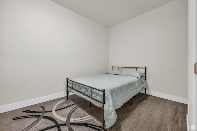 bedroom featuring baseboards and wood finished floors
