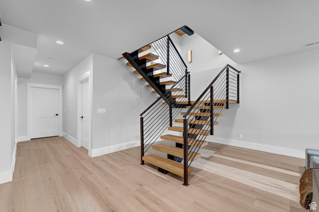 staircase featuring recessed lighting, visible vents, baseboards, and wood finished floors