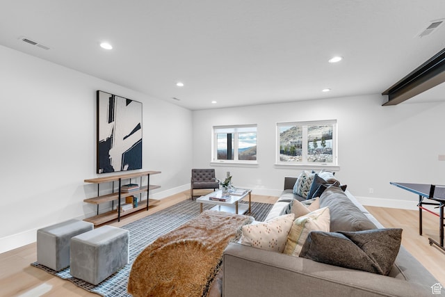 living room with baseboards, visible vents, light wood-style flooring, and recessed lighting