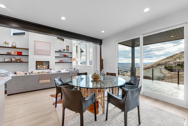 dining room with a mountain view, light wood finished floors, and recessed lighting