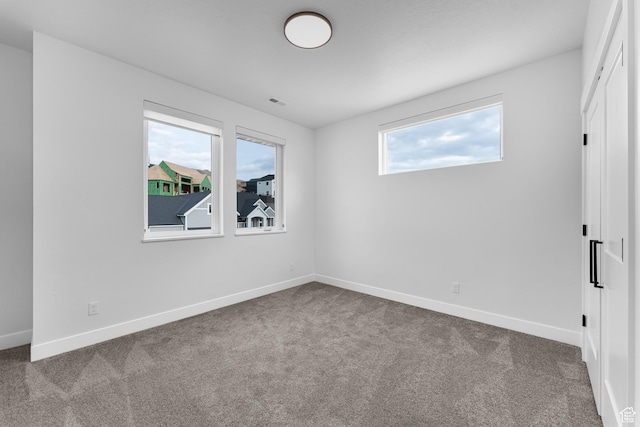 carpeted empty room with baseboards