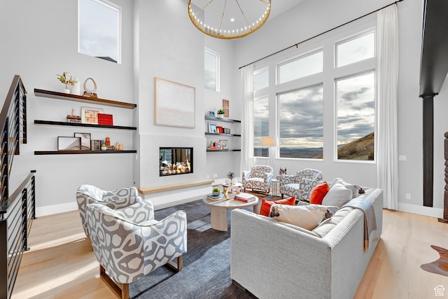 living area featuring wood finished floors, a glass covered fireplace, and a wealth of natural light