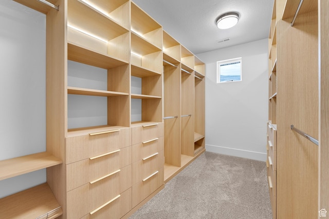 walk in closet with carpet floors and visible vents