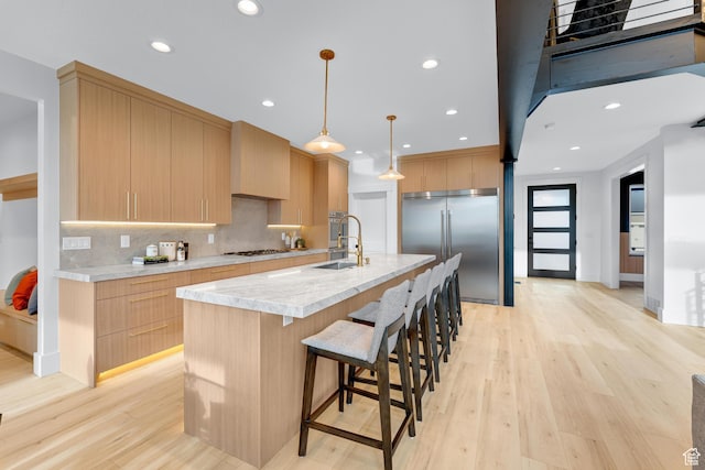 kitchen with light brown cabinets, light countertops, a sink, and appliances with stainless steel finishes