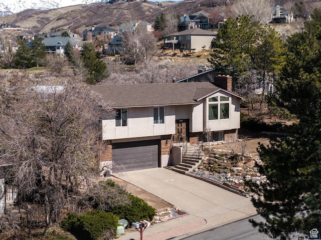 761 E Raygene Way S, North Salt Lake, UT 84054 - view of front of house featuring concrete driveway, a chimney, stucco siding, an attached garage, and a mountain view