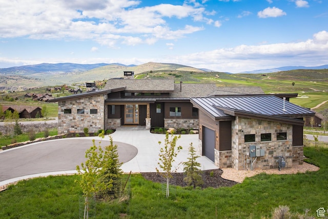 7045 E Moon Light Dr, Heber City, UT 84032 - view of front facade featuring stone siding, curved driveway, a standing seam roof, a mountain view, and an attached garage