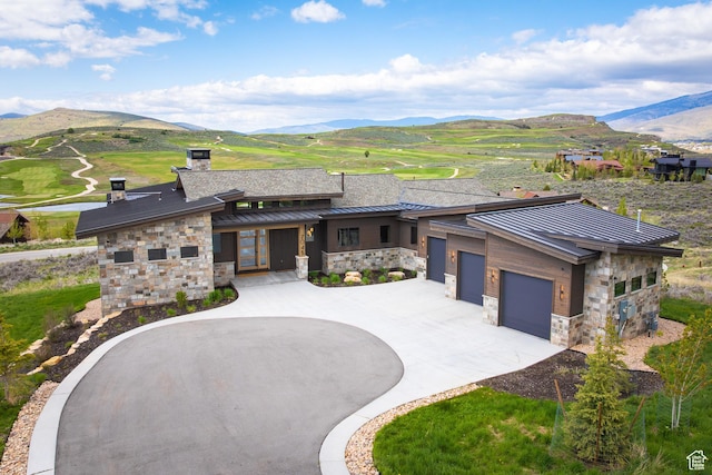 7045 E Moon Light Dr, Heber City, UT 84032 - view of front facade featuring a standing seam roof, a mountain view, stone siding, and curved driveway