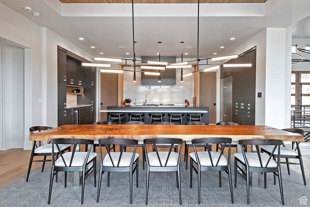7045 E Moon Light Dr, Heber City, UT 84032 - kitchen with a center island with sink, light wood-style floors, a tray ceiling, backsplash, and recessed lighting