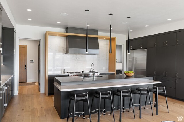 7045 E Moon Light Dr, Heber City, UT 84032 - kitchen with stainless steel built in refrigerator, dark cabinets, a kitchen island with sink, a breakfast bar area, and recessed lighting