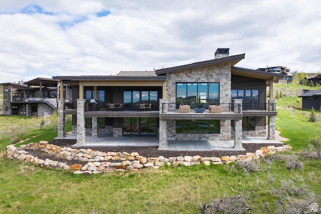 7045 E Moon Light Dr, Heber City, UT 84032 - back of property featuring stone siding, a patio, a balcony, and a chimney